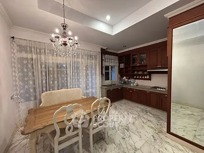 Elegant kitchen with marble floors, wooden cabinetry, and a classic chandelier, perfect for stylish dining.