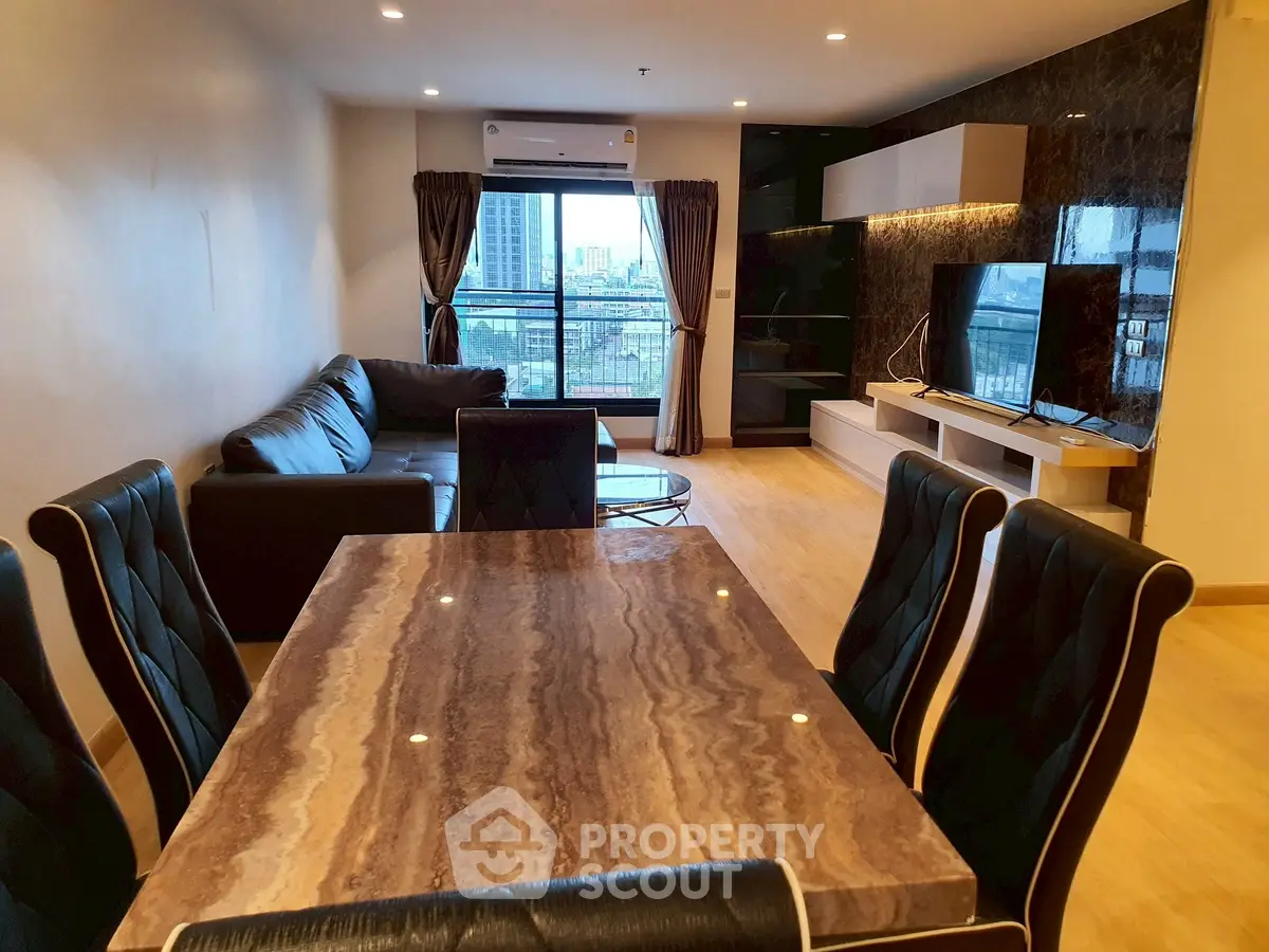 Spacious modern living room with elegant dining area and city view balcony.