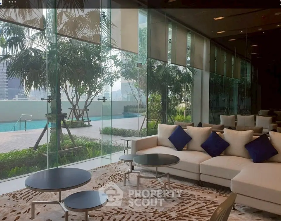 Luxurious living room with pool view, modern furniture, and floor-to-ceiling windows in a high-end property.