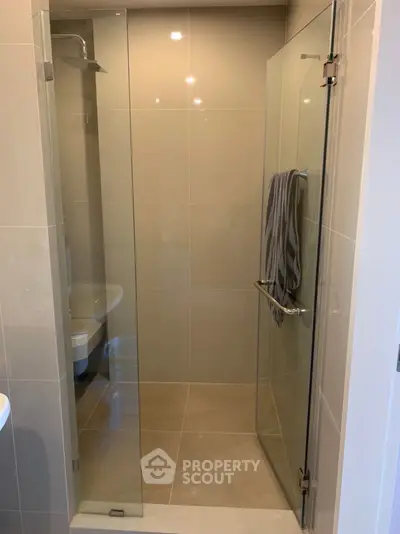 Modern bathroom with glass shower enclosure and sleek design.