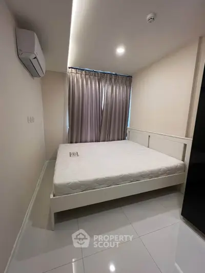 Modern bedroom with sleek design, featuring a comfortable bed and air conditioning for ultimate relaxation.