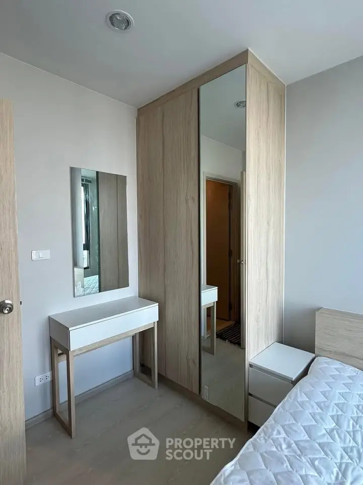 Modern bedroom with sleek wardrobe and stylish vanity in a contemporary apartment.