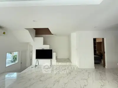 Modern minimalist living room with marble flooring and sleek TV setup