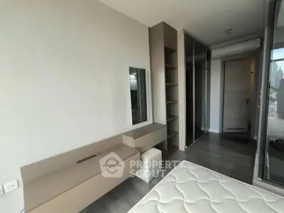 Modern bedroom with sleek furniture and large closet in a stylish apartment.