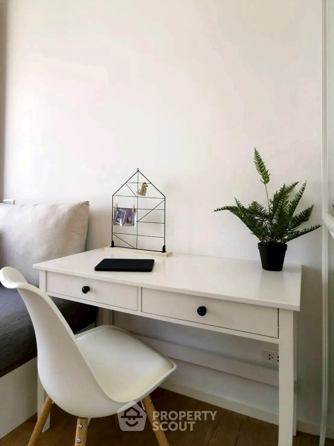Cozy study nook with modern white desk and chair, perfect for productivity.