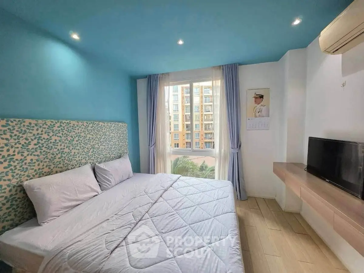 Bright and cozy bedroom with modern decor and large window offering a city view.