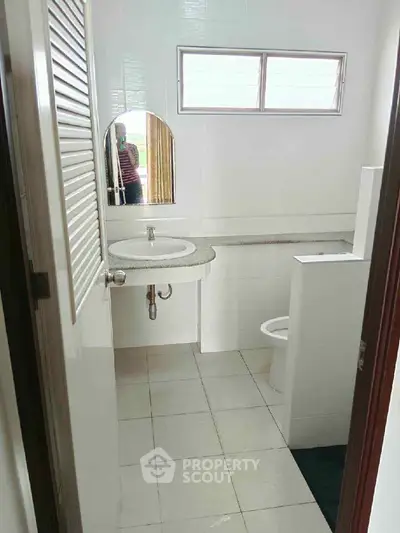 Compact bathroom with modern fixtures and natural light