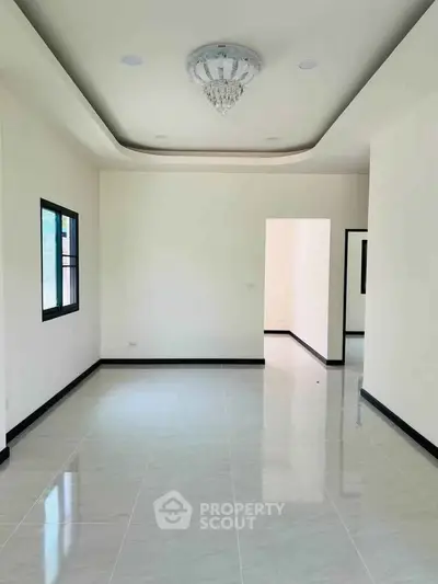 Spacious modern living room with elegant ceiling design and large windows.