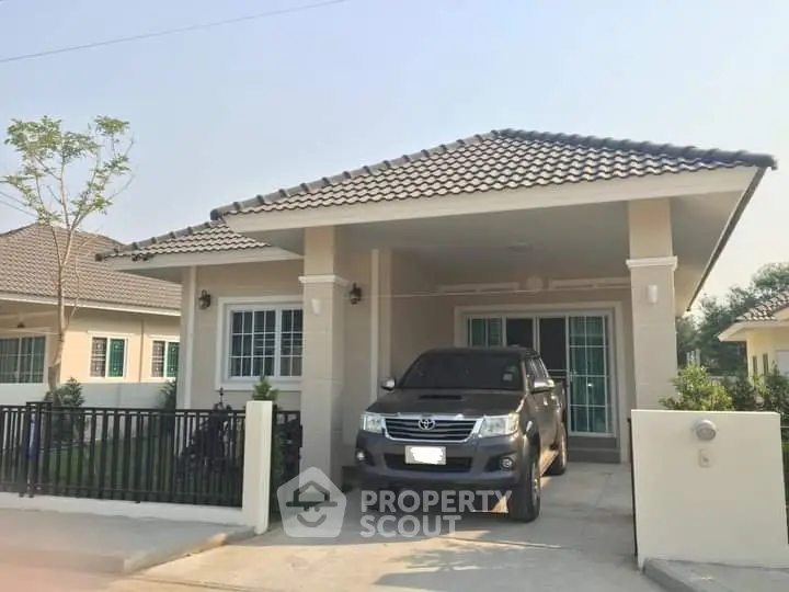 Charming single-story house with tiled roof and driveway in a serene neighborhood.
