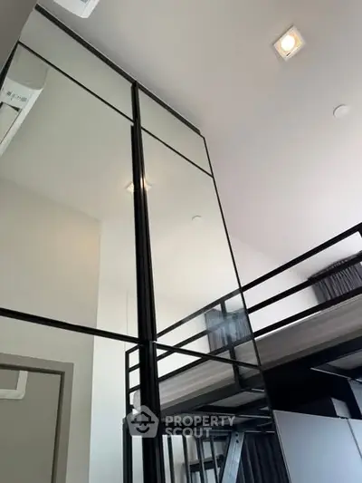 Modern loft-style bedroom with high ceilings and sleek design