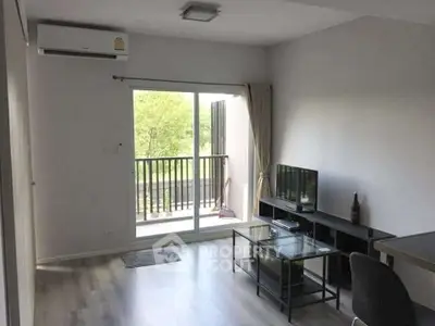 Modern living room with balcony view, featuring sleek furniture and natural light.