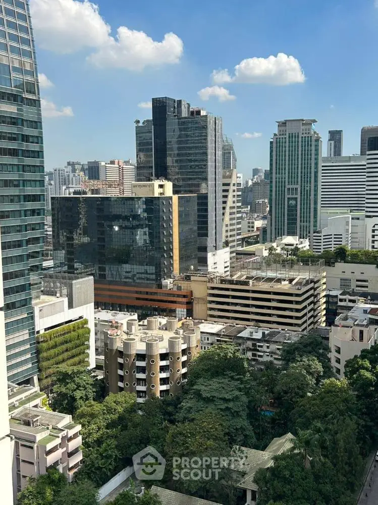 Stunning cityscape view from high-rise building showcasing urban architecture and lush greenery.