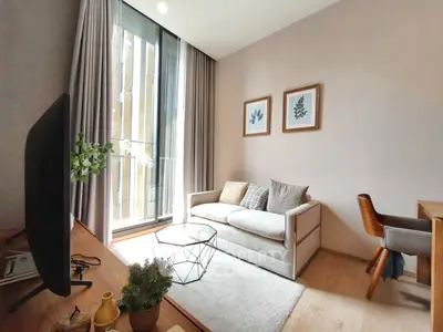 Modern living room with cozy sofa, stylish decor, and natural light from large window.