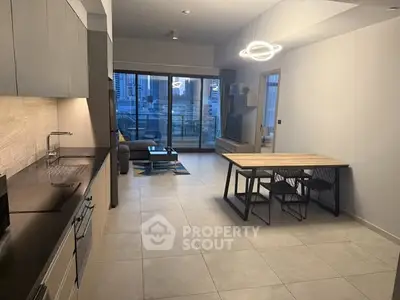 Modern open-plan kitchen and living area with sleek design and balcony view.