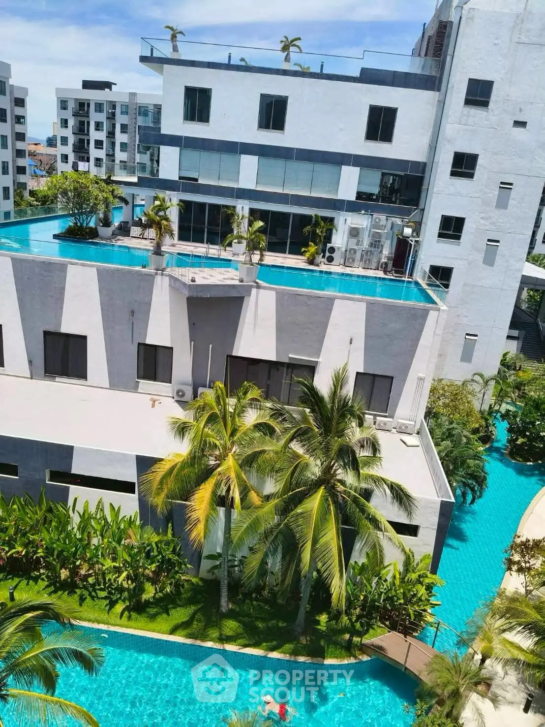 Luxurious apartment complex with rooftop pool and lush greenery