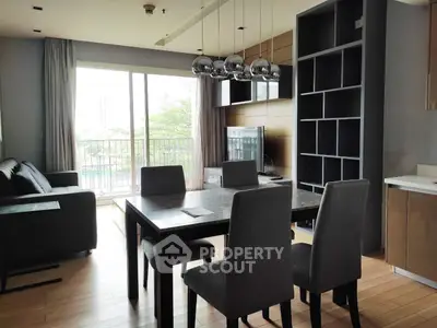 Modern living room with dining area and balcony view in a stylish apartment.