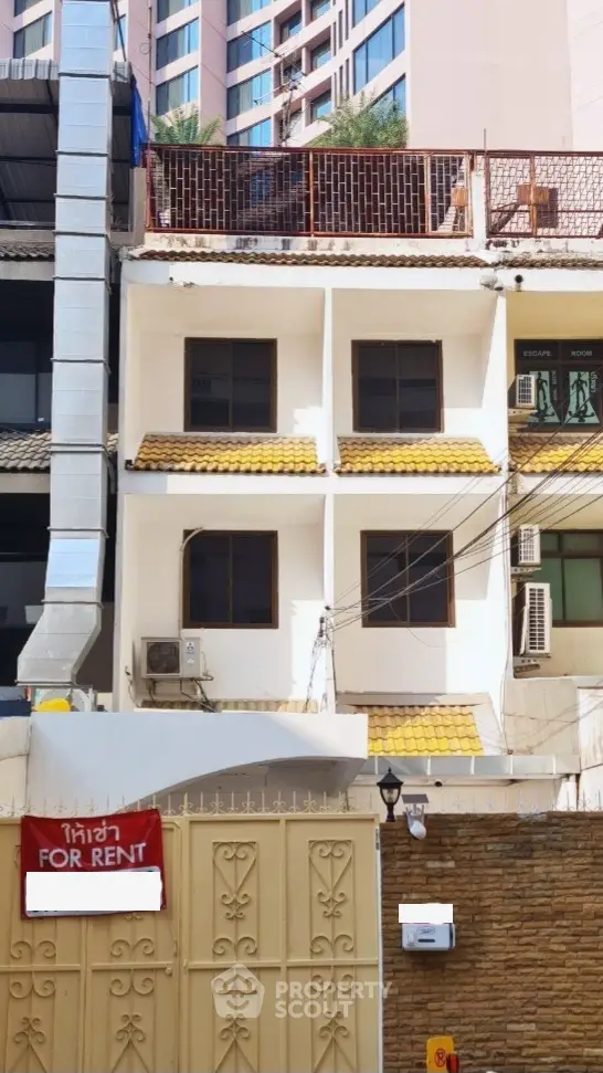 Charming multi-story building for rent with spacious balconies and terracotta roof tiles nestled in a vibrant neighborhood, offering a blend of comfort and convenience.