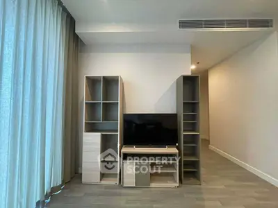 Modern living room with sleek TV stand and shelving units, featuring elegant curtains and minimalist design.