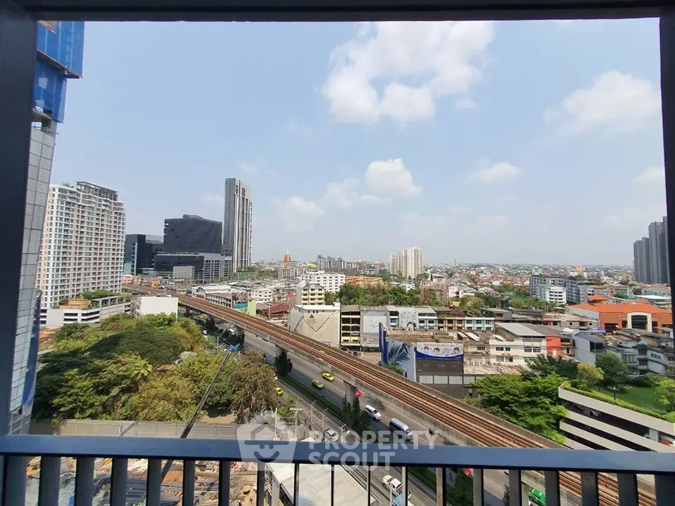 Stunning cityscape view from high-rise balcony overlooking urban skyline and railway.