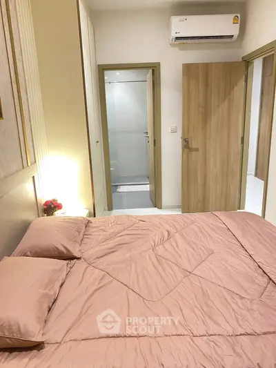 Cozy bedroom with modern air conditioning and ensuite bathroom in stylish apartment.