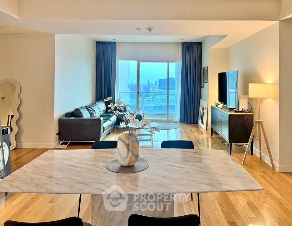 Luxurious open-plan living room with city view, featuring modern furniture and elegant decor.