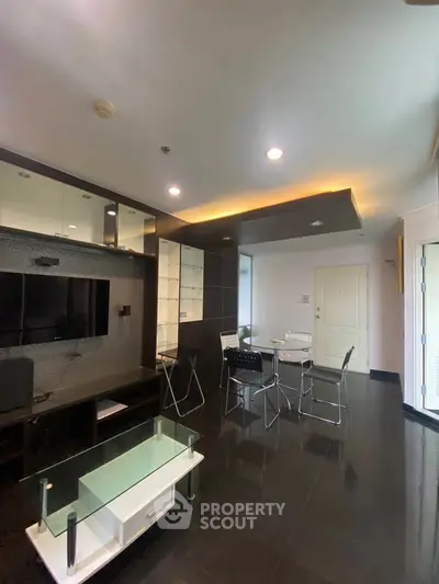 Modern living room with sleek black flooring and stylish furniture in a contemporary apartment.