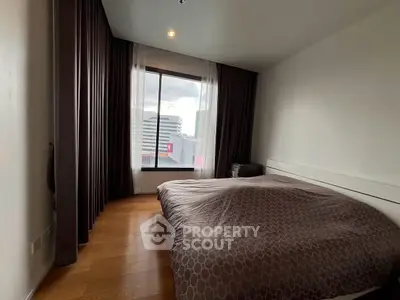 Cozy bedroom with large window and modern decor in urban apartment