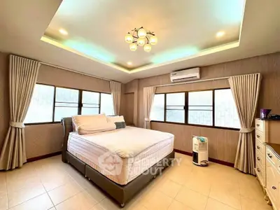 Spacious bedroom with elegant lighting and large windows in modern home