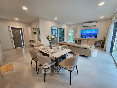 Spacious modern living room with dining area and large windows in Chiang Mai home.