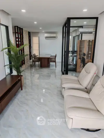 Spacious modern living room with sleek furniture and glass partitions