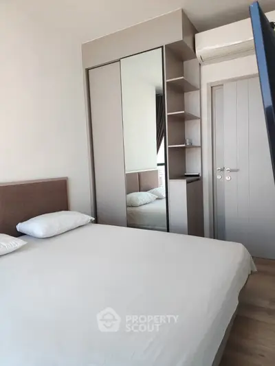 Modern bedroom with mirrored wardrobe and air conditioning unit