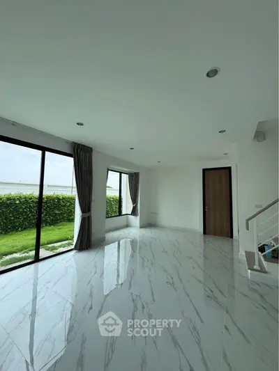 Spacious modern living room with large windows and garden view
