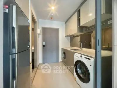 Modern kitchen with sleek appliances and washing machine in stylish apartment.