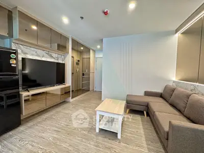 Modern living room with sleek design, featuring a comfortable sofa, flat-screen TV, and stylish decor.
