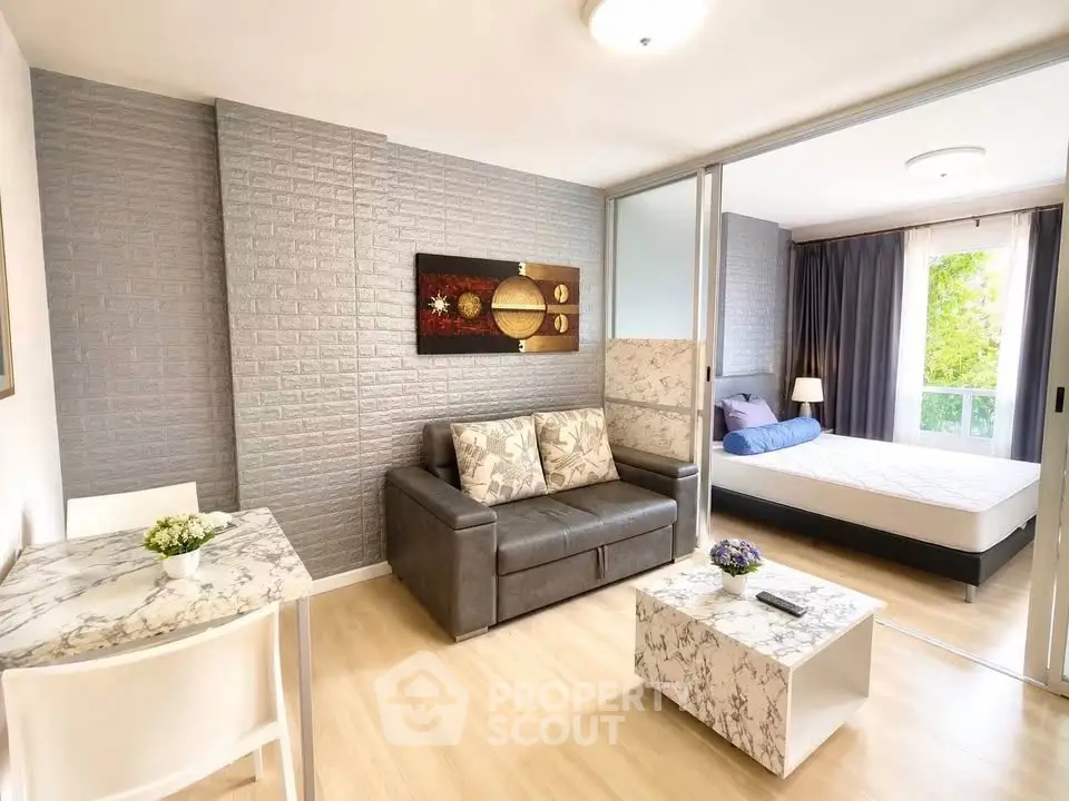 Modern living room with stylish decor and cozy bedroom in open layout apartment.