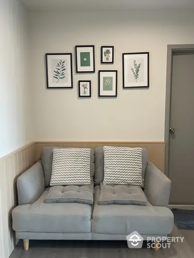 Cozy living room with stylish gray sofa and framed botanical art