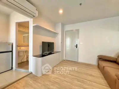 Modern living room with sleek design, featuring a TV, air conditioning, and stylish flooring.