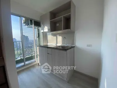 Modern kitchen with sleek cabinetry and balcony view in urban apartment