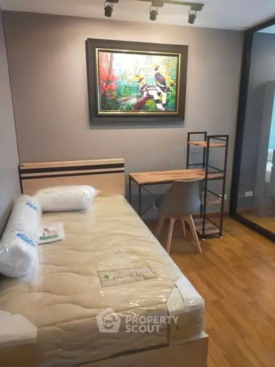 Cozy bedroom with modern furniture and vibrant artwork, perfect for a comfortable living space.