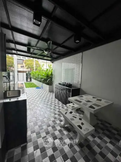 Chic outdoor kitchen with modern design and tiled flooring, perfect for entertaining.