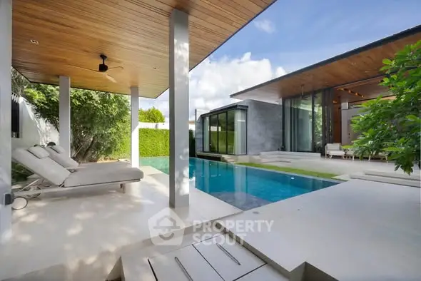 Luxurious modern home with sleek pool and stylish outdoor lounge area.