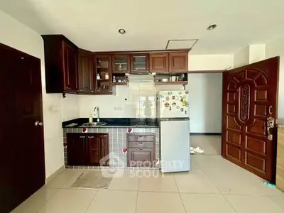 Charming kitchen with wooden cabinets and modern appliances in a cozy apartment setting.