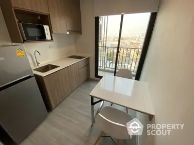 Modern compact kitchen with city view, featuring sleek cabinetry and dining area.