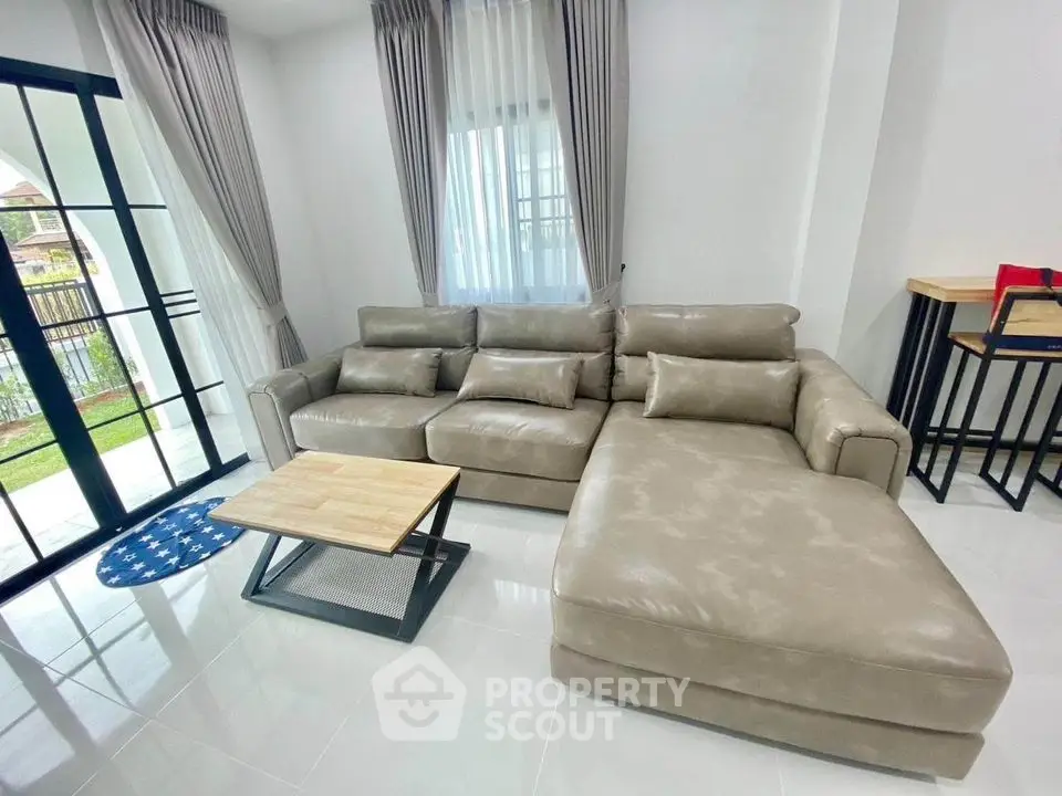 Spacious living room with modern leather sectional sofa and natural light