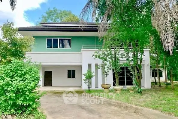 Charming two-story house with lush greenery and spacious driveway