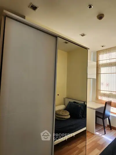Cozy bedroom with modern wardrobe and study desk, perfect for urban living.