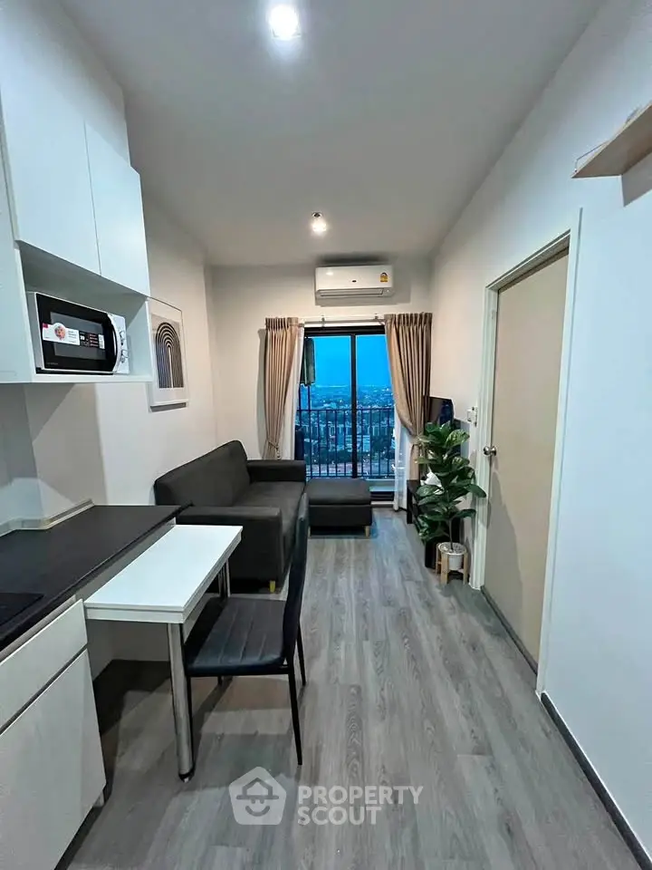 Modern living room with sleek furniture and city view from balcony, perfect for urban living.