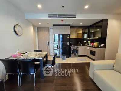 Modern open-layout kitchen with dining area and sleek appliances in a stylish apartment.
