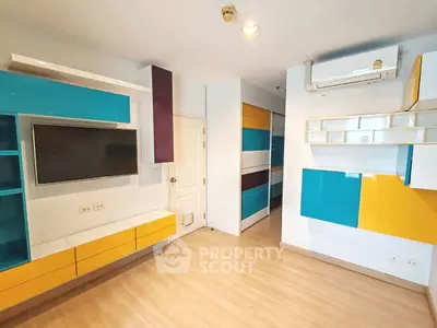Modern living room with colorful built-in shelves and wall-mounted TV