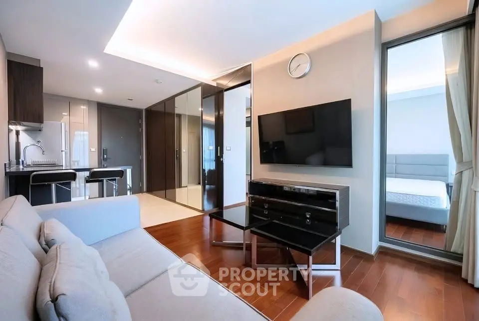 Modern living room with sleek design and open layout, featuring a wall-mounted TV and stylish furniture.